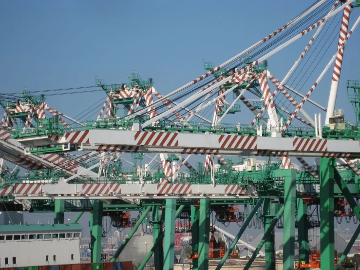 some green and red cargo cranes and a bridge