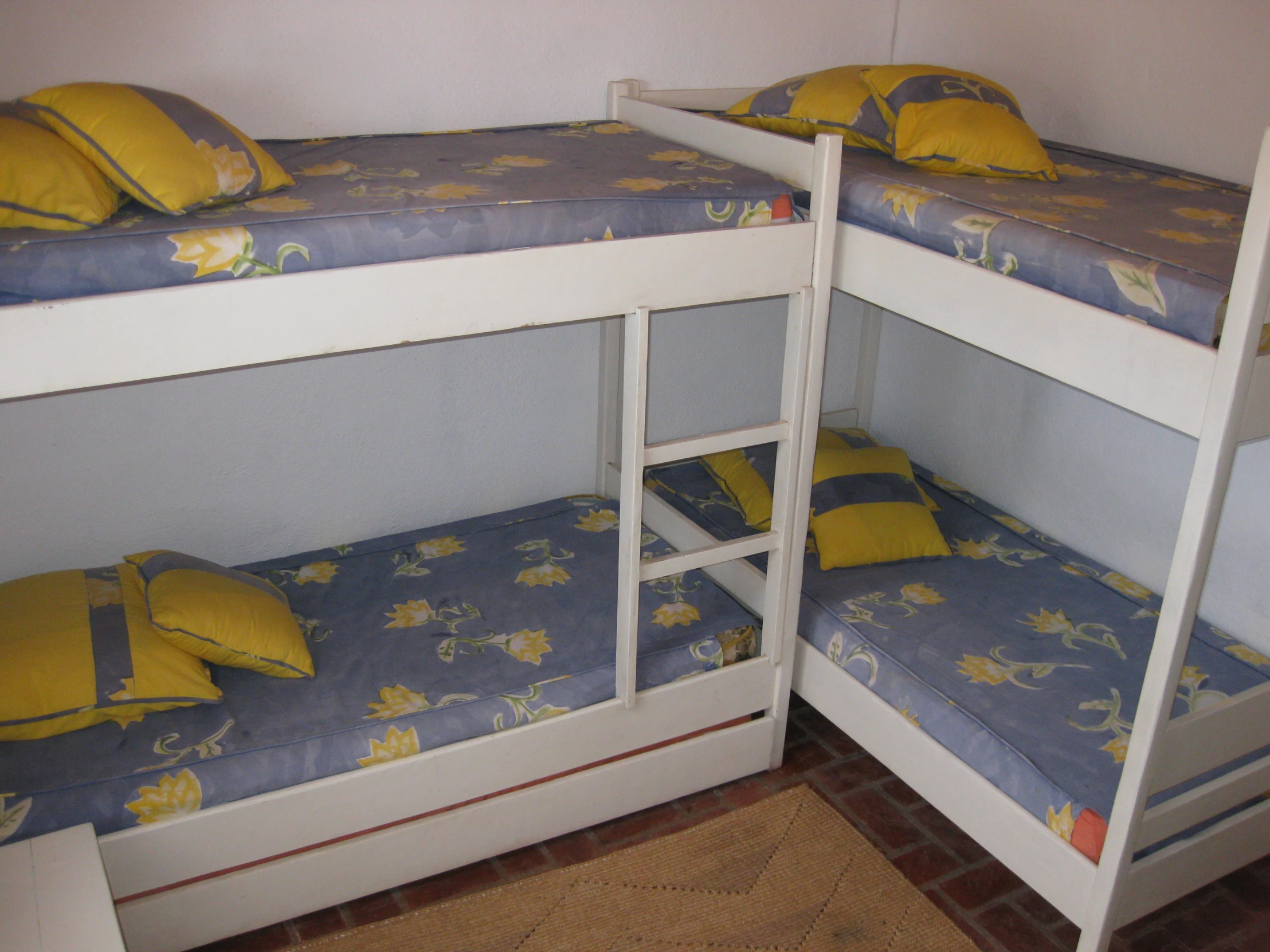 a couple of bunk beds with blue and yellow sheets