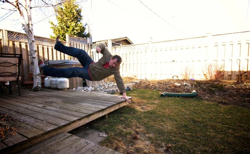 a man doing an ollie in the backyard