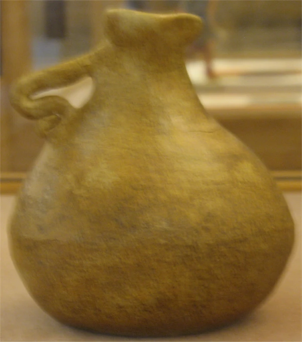a brown and green colored ceramic vase sitting on the floor