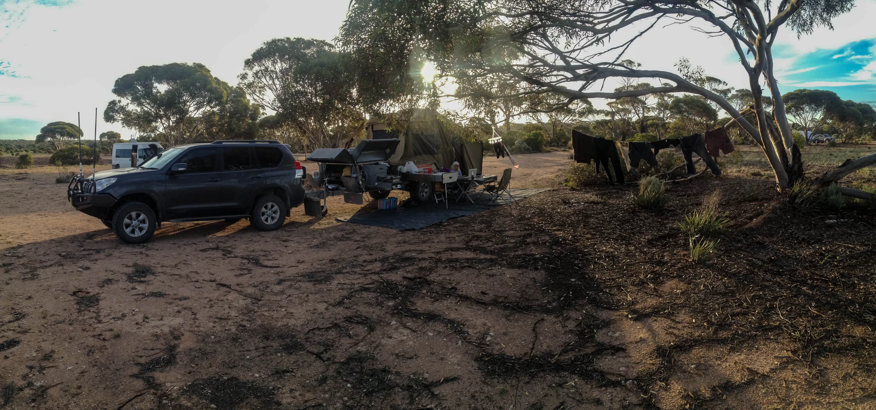 a truck and two horses standing in the dirt