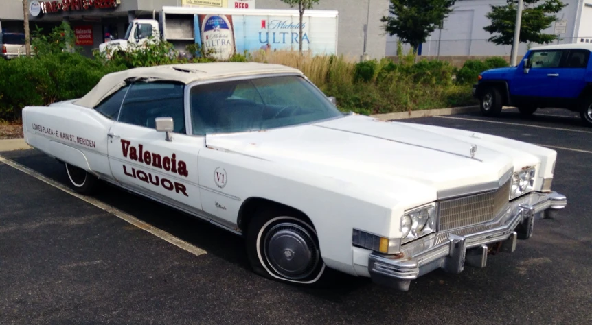 an old white car with advertits painted on the side