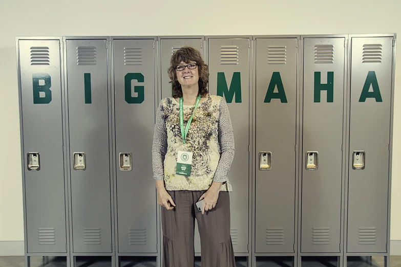 a woman standing in front of two gray lockers