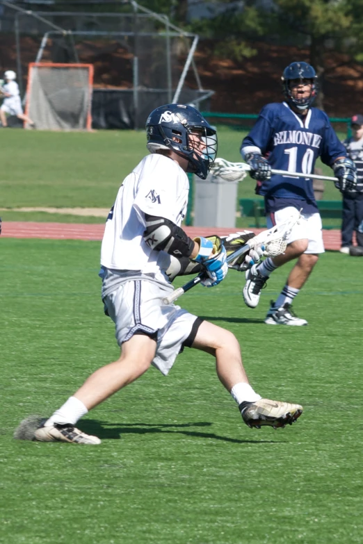 a boy running with a lacrosse ball wearing gloves