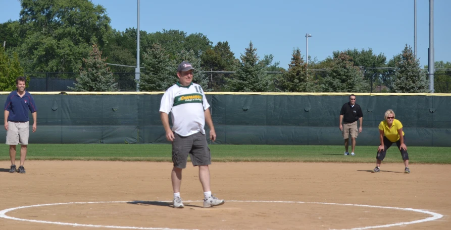 two teams playing baseball in a park while people watch