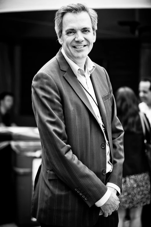 an image of a man smiling while wearing a suit