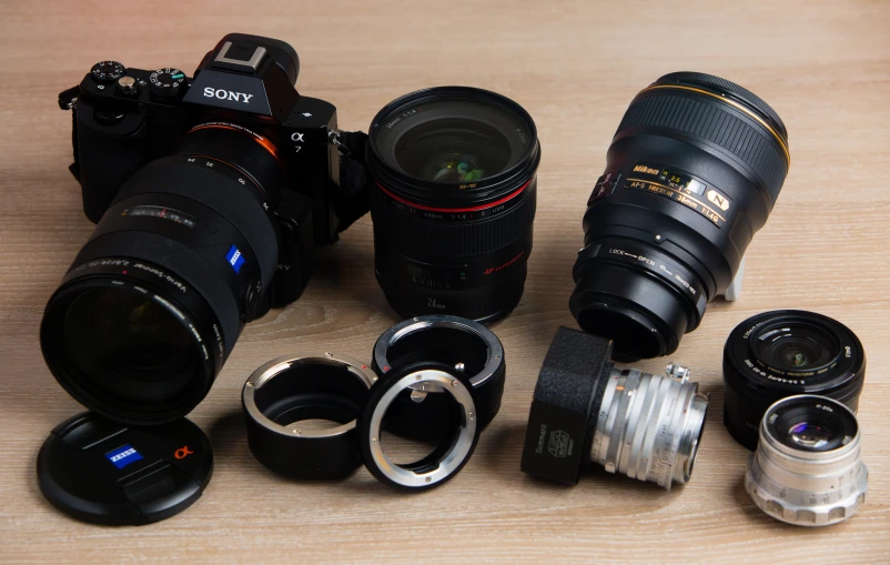 cameras and lenses sitting on a table together