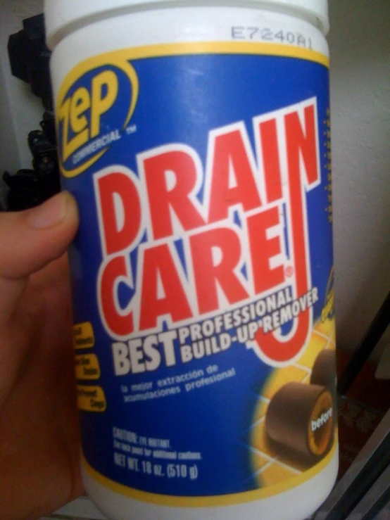 a person holding a plastic bottle with the word drain care written on it