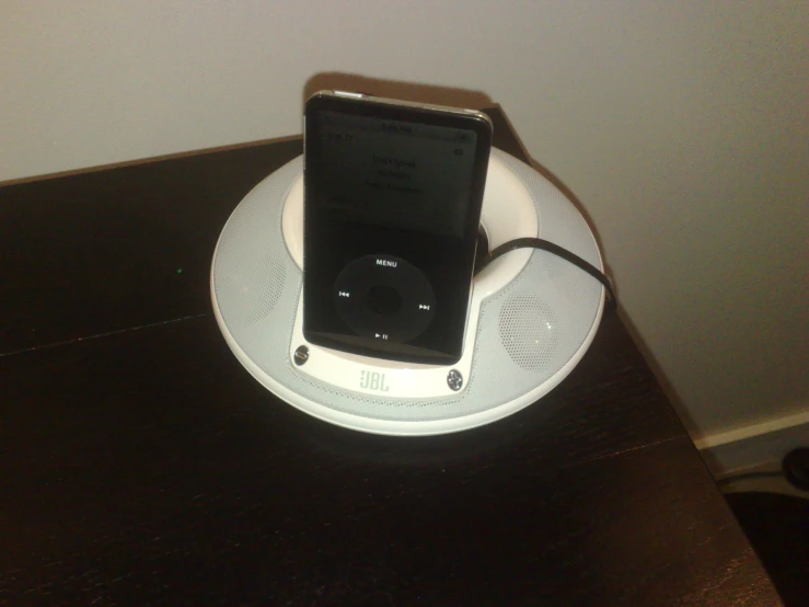 an ipod is charging on top of an ipod