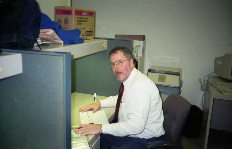 an office worker is sitting at his desk and checking some notes