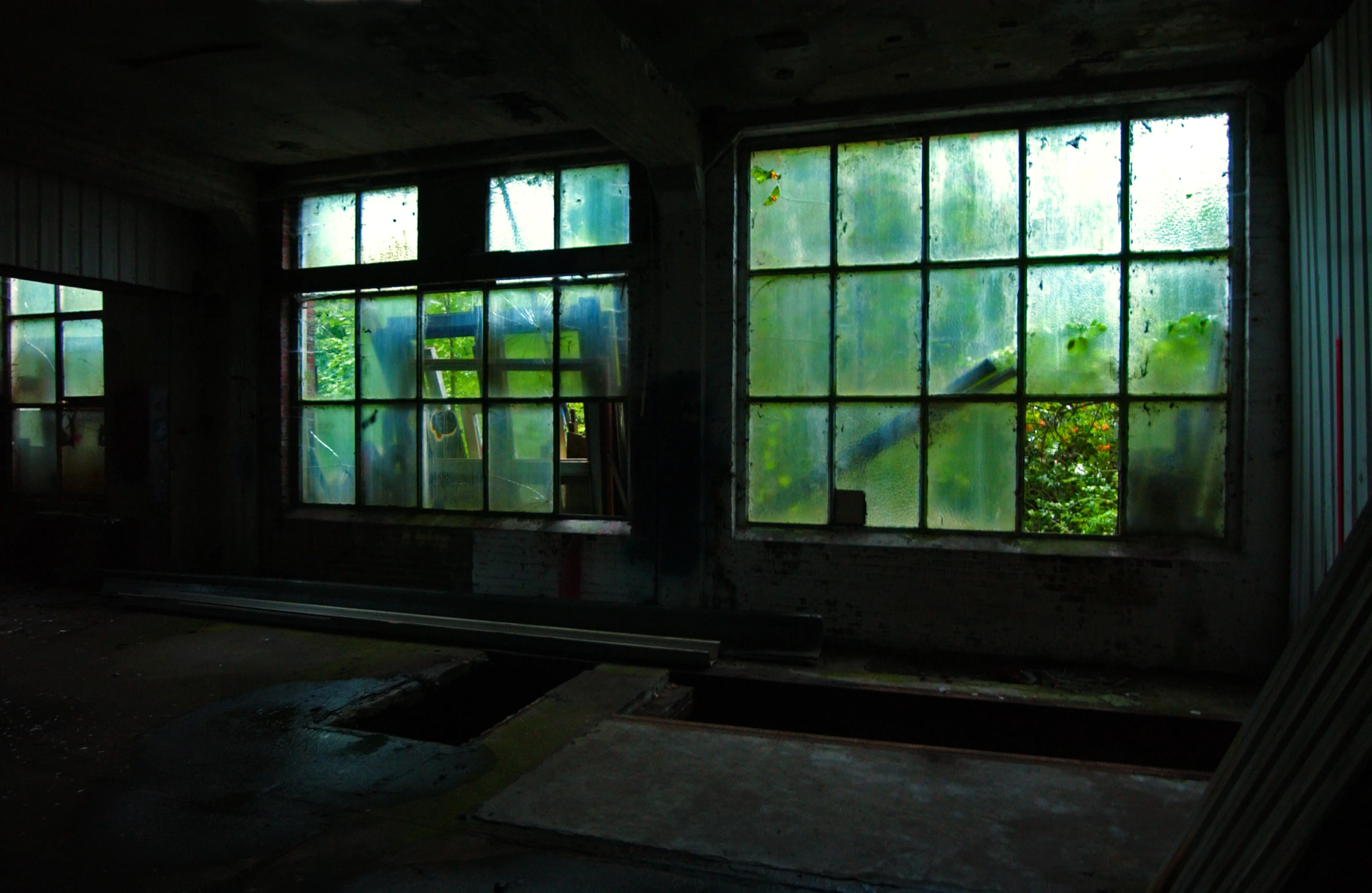 there are three large windows in this abandoned building