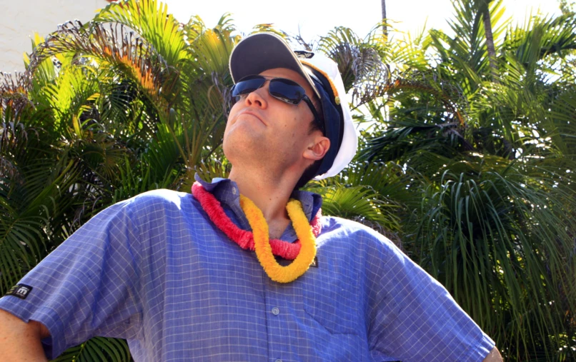 a man is wearing a flower garland and hat