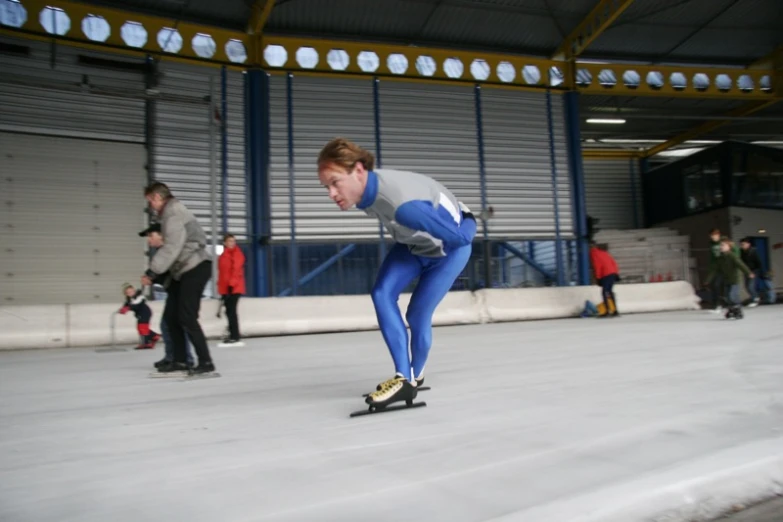 a women in a blue tight bodysuit skates