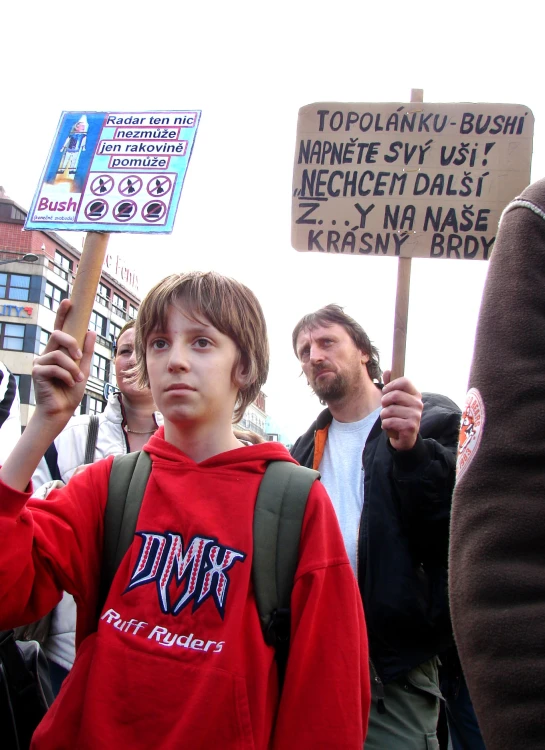 a boy in a hoodie holding up a sign