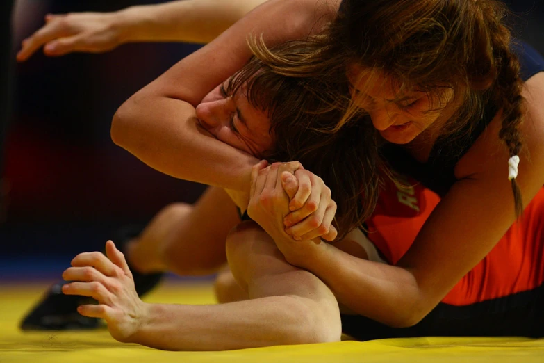 a woman wrestling and the other girl leaning over her head