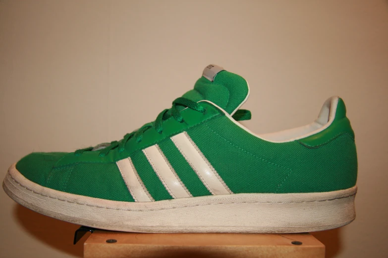 the sneakers have three stripes on them and are green