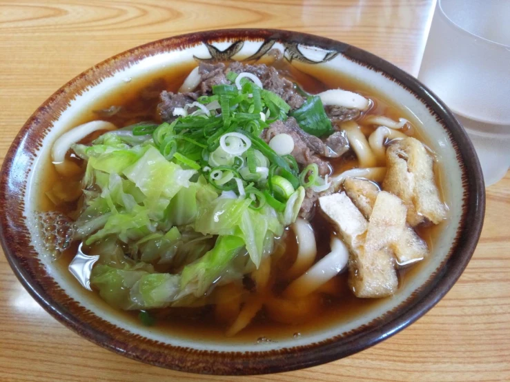 a bowl filled with meat, noodles, and vegetables