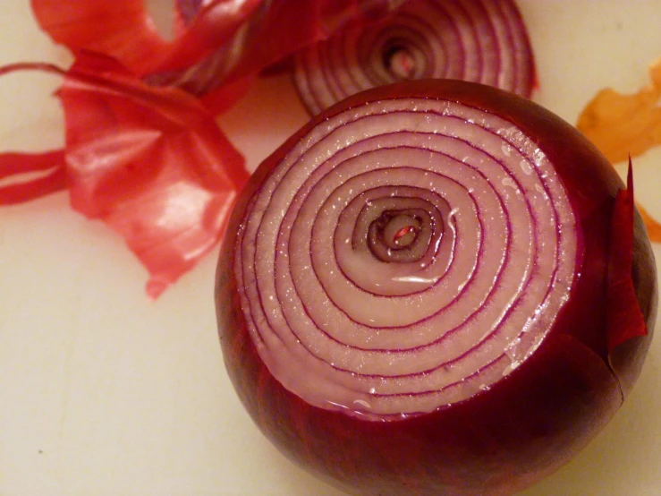 a red onion is cut into halves and placed on a  board