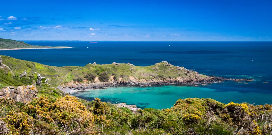 green hills surrounding an ocean with blue water