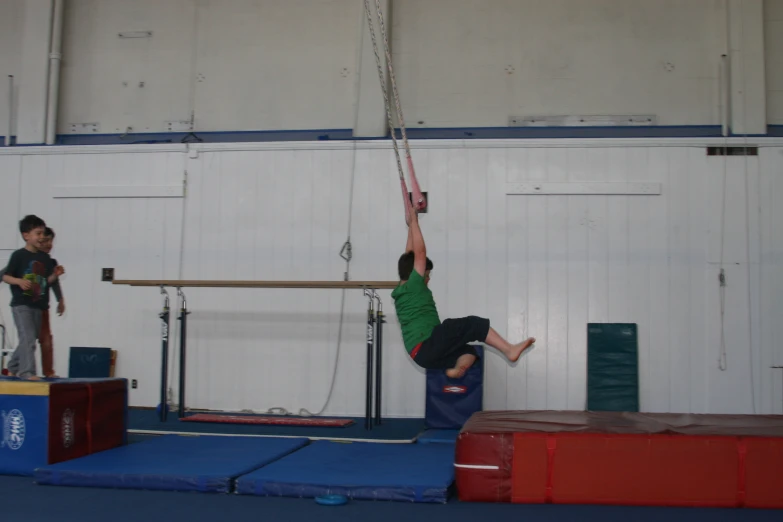 a man is suspended on a rope above two other people