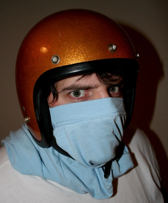 man with motorcycle helmet over his face wearing a protective mask