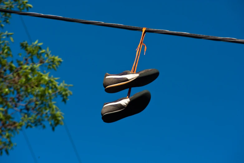 a couple of shoes hanging up against a wire