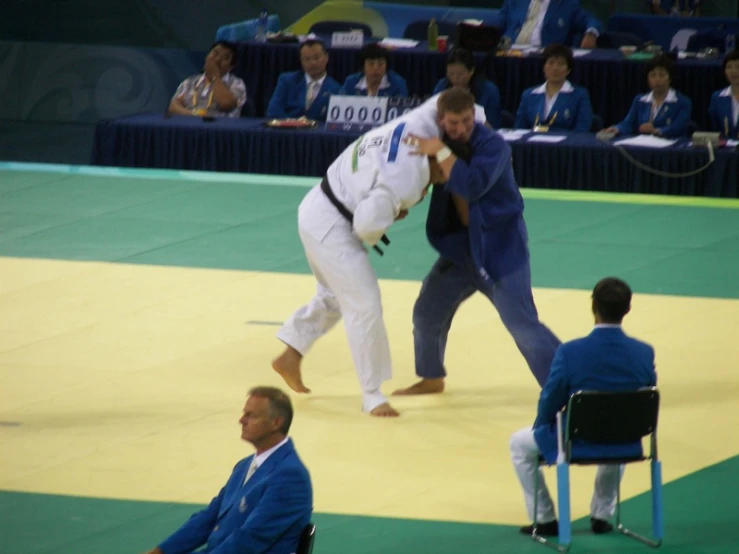 a man throwing a wrestling coach in an indoor match