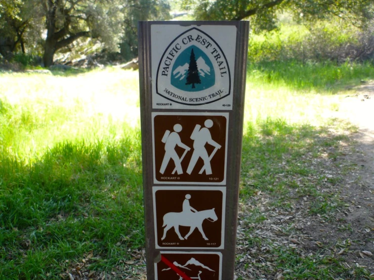 a sign on the grass warning the trails and hikers