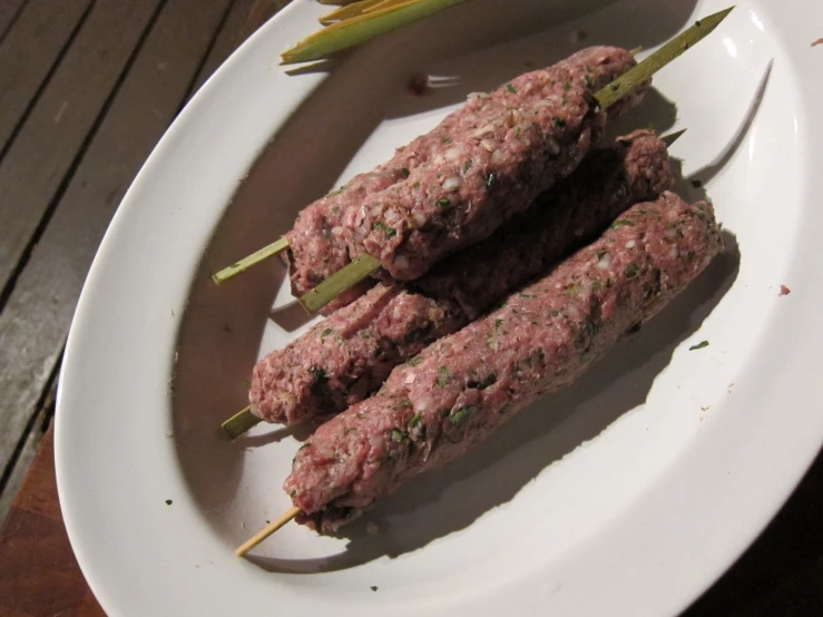 a plate of meat skewers sitting on a table