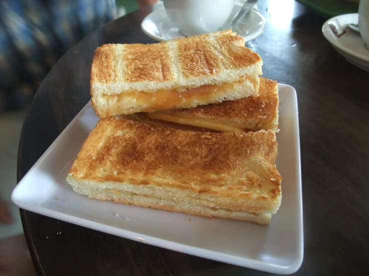 two grilled cheese sandwiches are stacked on a plate