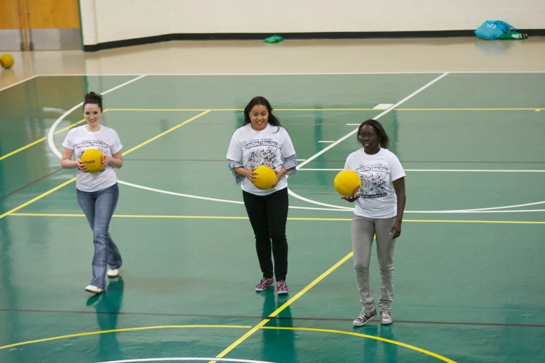 three women holding yellow and black balls in their hands