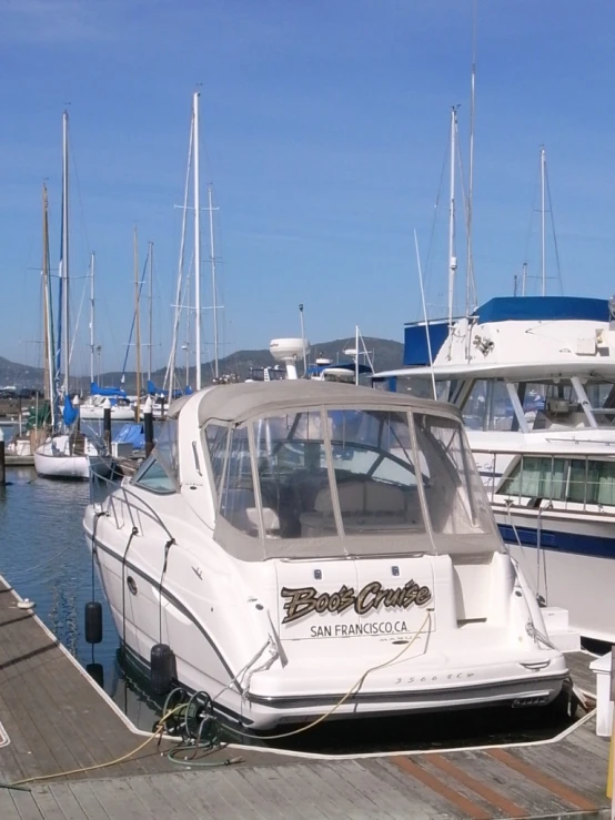 a white boat docked in front of a marina