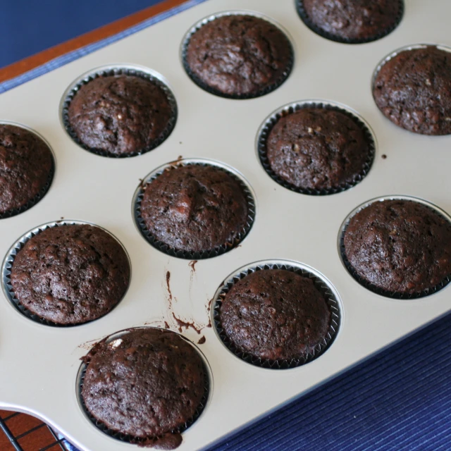a muffin tray with chocolate cup cakes in it