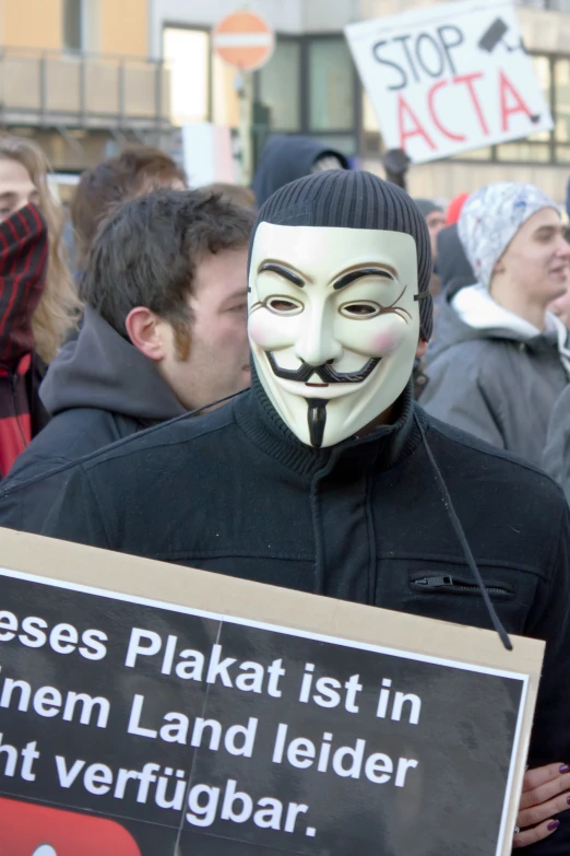 man holding protest sign wearing a black mask