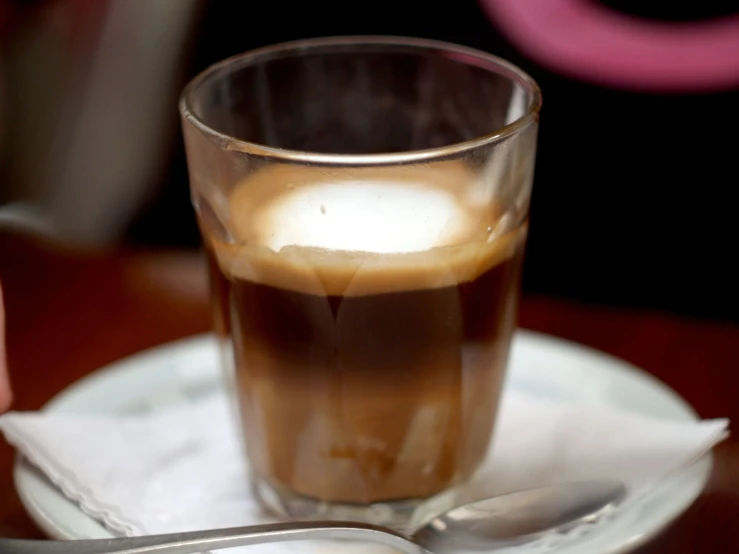 a cup on a table with a spoon and saucer