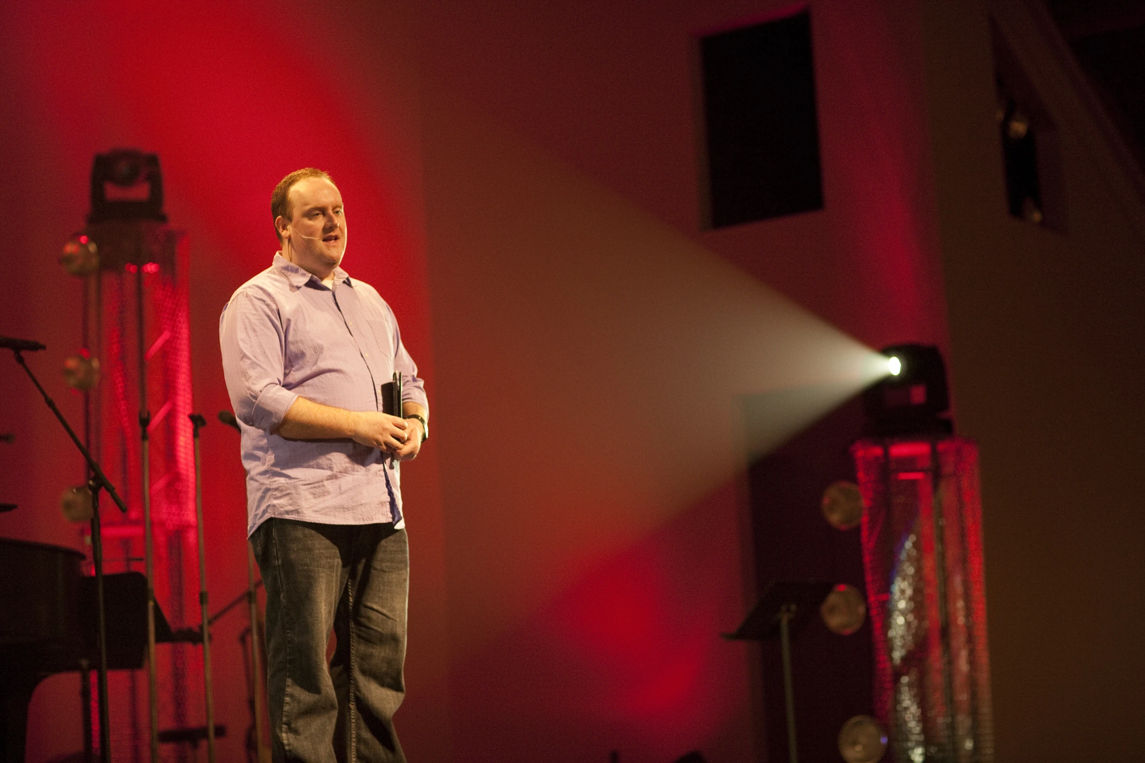 man standing on stage and speaking into microphone