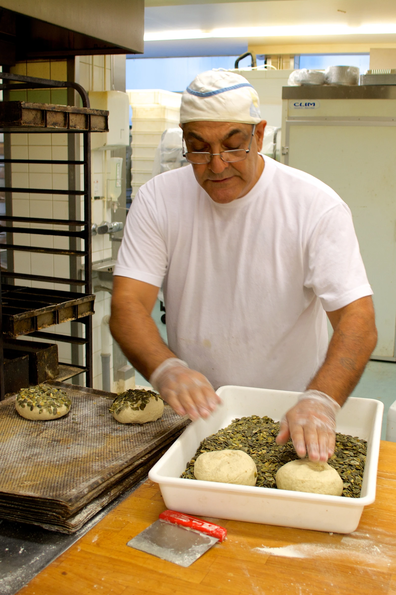 a person putting soing into a dish in an industrial kitchen