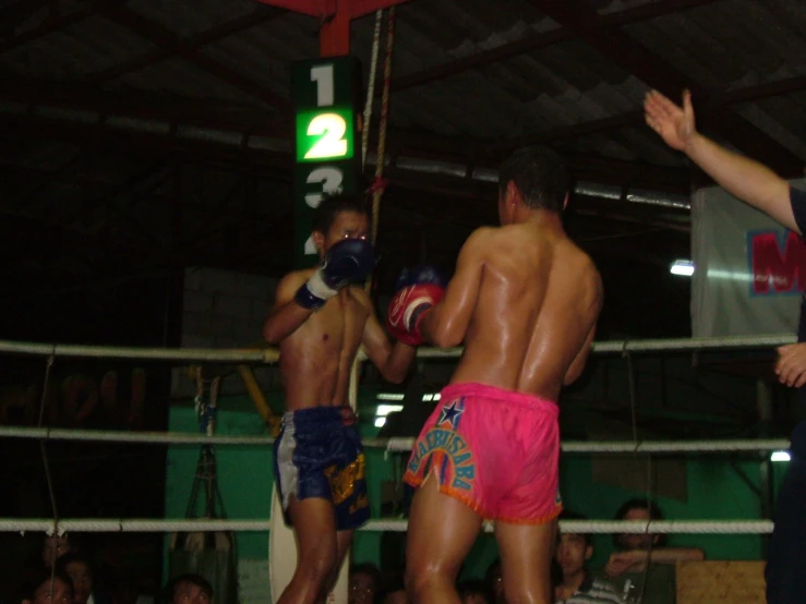 two boxers are near one another in a boxing ring