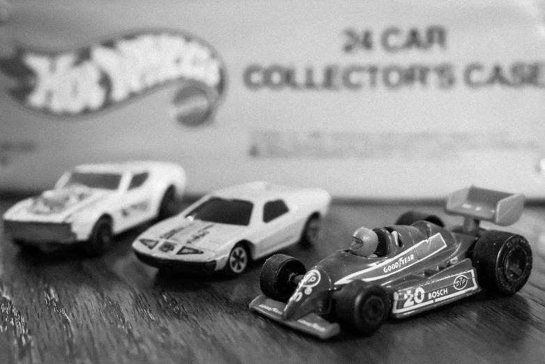 toy cars parked on a desk next to a sign