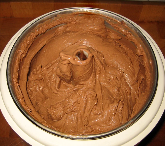 a bowl filled with chocolate frosting on top of a table