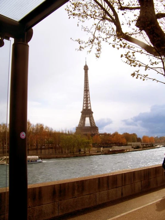 a woman walking down the sidewalk in front of a large body of water