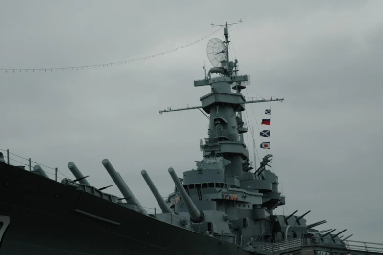 a naval ship with guns in the foreground