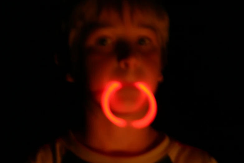 a man making a face while holding a neon item in his mouth