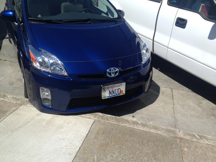 a toyota car parked in front of a white truck