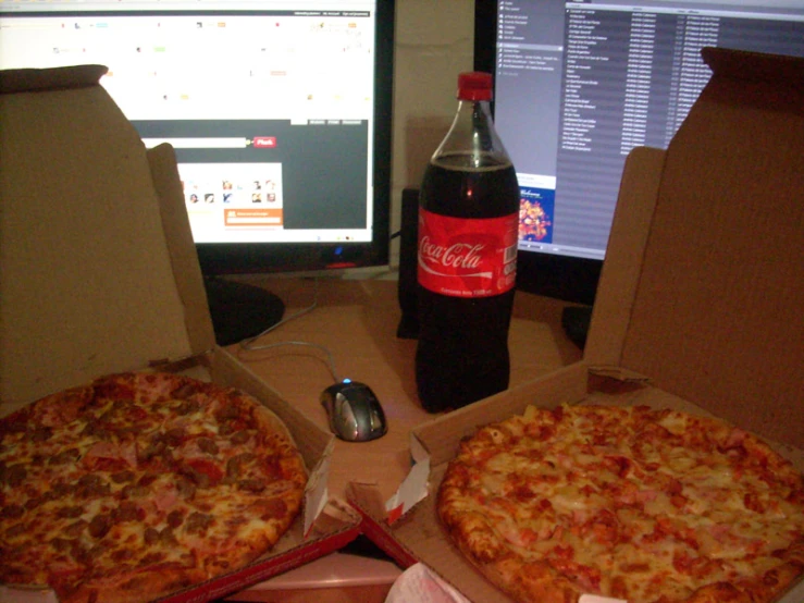 there are two large pizzas in front of the computer