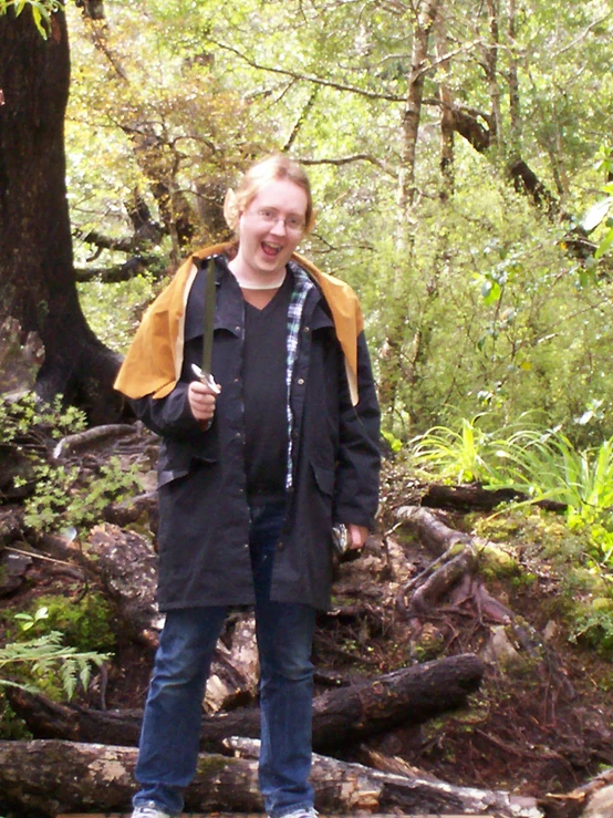 a person standing on a log in the woods