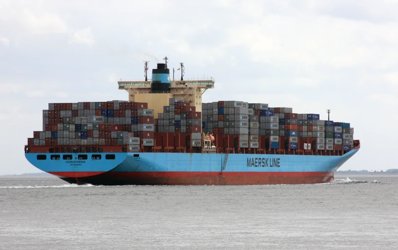 a large ship loaded with lots of containers sailing on the water