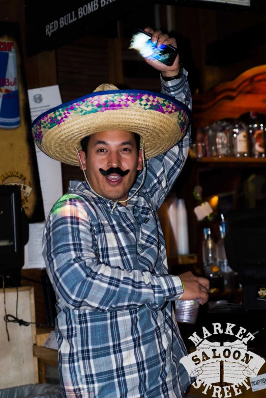 a man in mexican attire holding up a beer