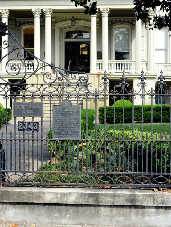 an iron gated sidewalk leading to a large house