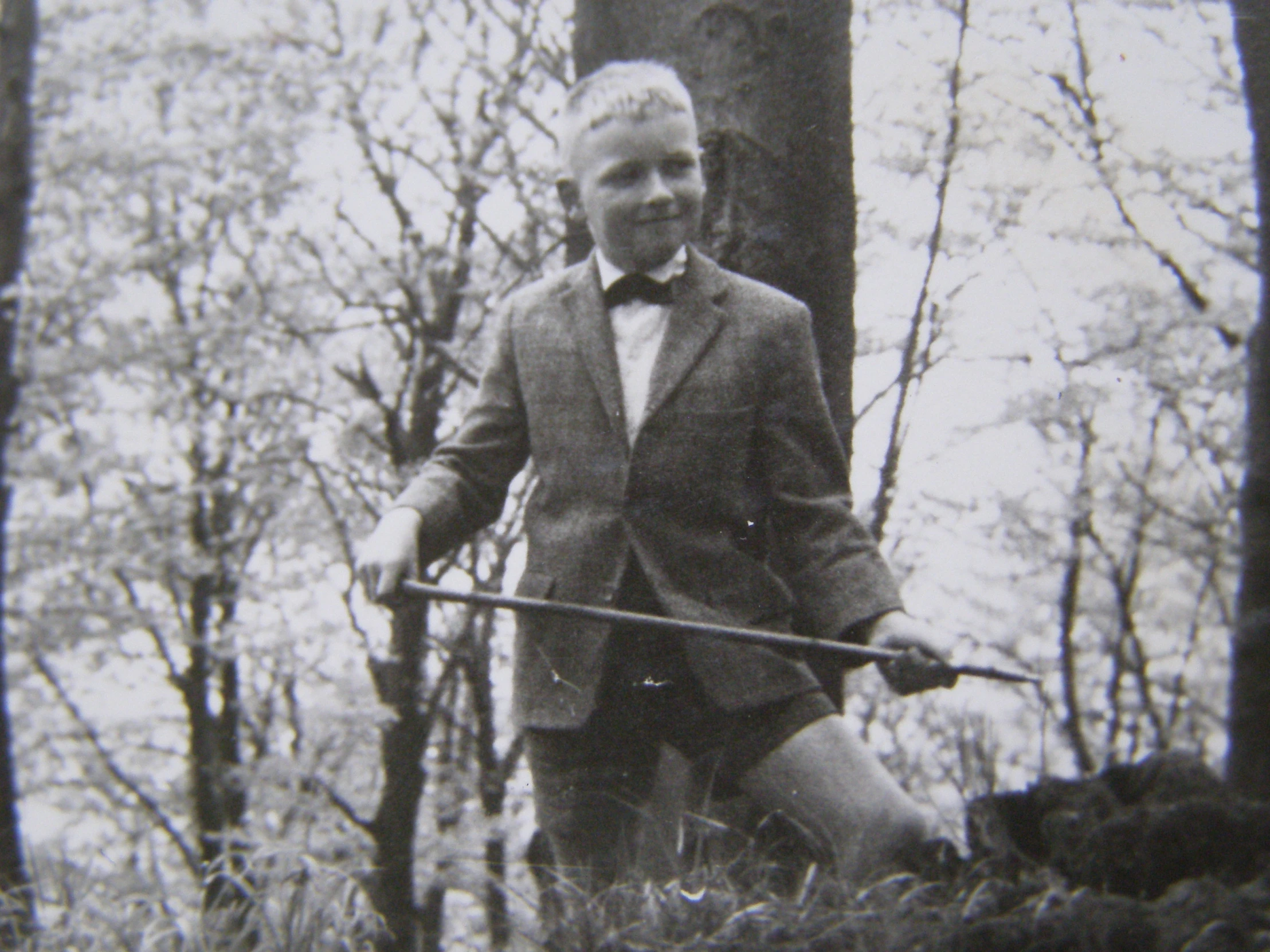 an old po of a man in a suit with a cane in the woods